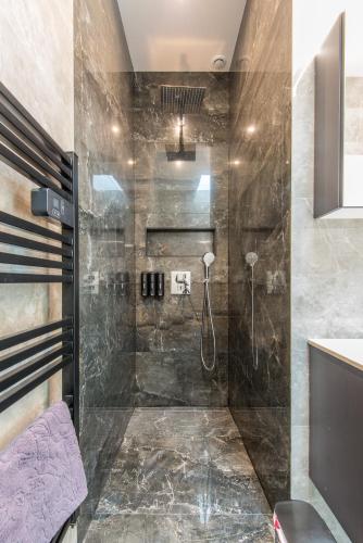 une salle de bain avec une douche à l'italienne à côté d'un lavabo dans l'établissement Jolie maison au calme, à Menton