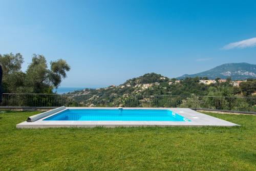 芒通的住宿－Jolie maison au calme，一座位于庭院内的游泳池,山丘位于酒店后面