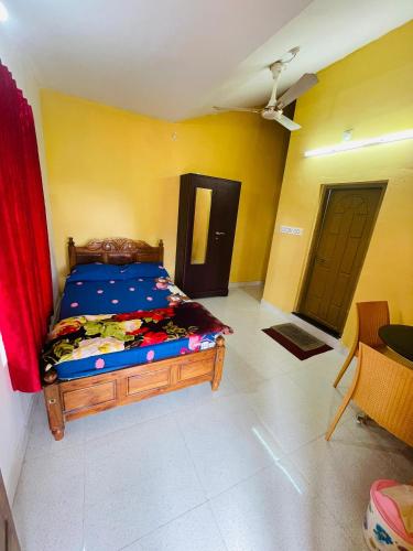 a bedroom with a bed in a room with yellow walls at Best Mist in Idukki
