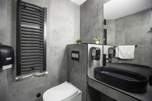a bathroom with a sink and a toilet at 4 Rooms Apartments in Niš