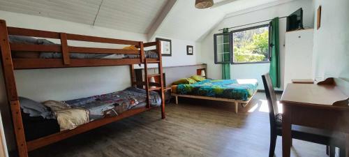 a room with two bunk beds and a desk at La ch'tite montagne in Cilaos