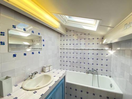 La salle de bains est pourvue d'un lavabo et d'une baignoire. dans l'établissement 06AW - Mas en pierre provençal rénové au calme, à Le Rouret