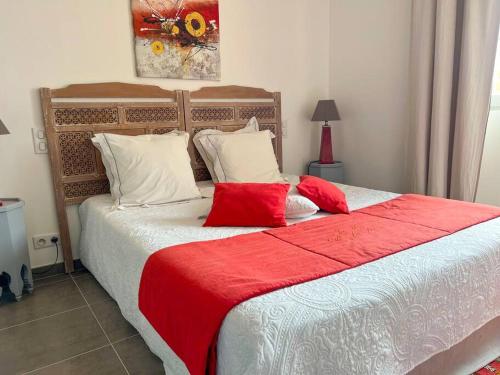 a bedroom with a large bed with a red blanket at Mas provençal avec piscine in Tourrettes-sur-Loup