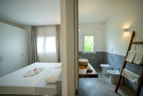 a hotel room with a bed and a bathroom at OceanView Villa Manzini with Private Pool ZanzibarHouses in Kiwengwa