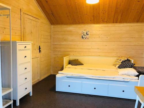 ein Schlafzimmer mit einem Bett in einem Holzzimmer in der Unterkunft Ranczo Neverlandia 