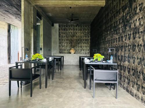 a dining room with black tables and black chairs at Saffron Robes Living in Hikkaduwa