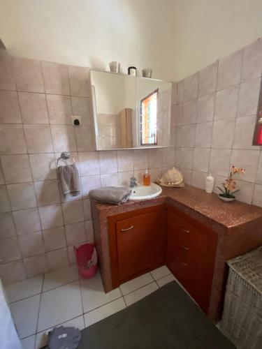 W łazience znajduje się umywalka i lustro. w obiekcie Villa Nova POOL own compound 8min walk to the beach Diani Beach w mieście Ukunda