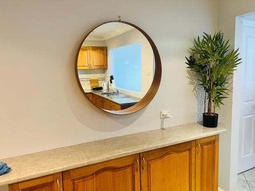 baño con lavabo y espejo en la pared en Ocean-View Retreat for Family Getaways, en Cringila