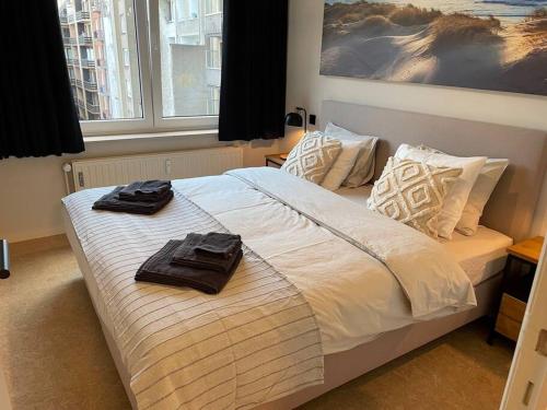 een slaapkamer met een bed met twee handdoeken erop bij Appartement Wouters in Oostende