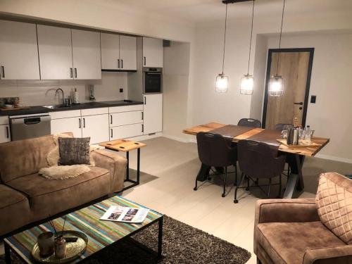 een woonkamer met een bank en een tafel en een keuken bij Appartement Wouters in Oostende