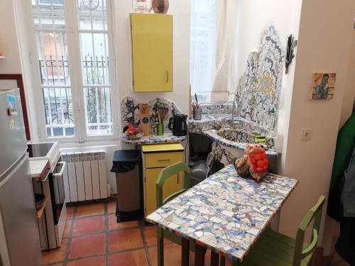 a kitchen with a table and a counter top at Charmant studio atypique in Paris