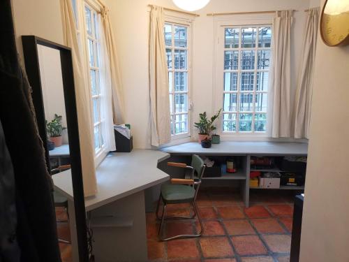 パリにあるCharmant studio atypiqueのデスクと2つの窓が備わる客室です。