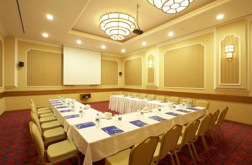 a conference room with tables and chairs and a screen at Ankara Plaza Hotel in Ankara