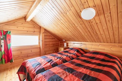 a bedroom with a bed in a wooden cabin at Pyhä Nallentupa in Pyhätunturi
