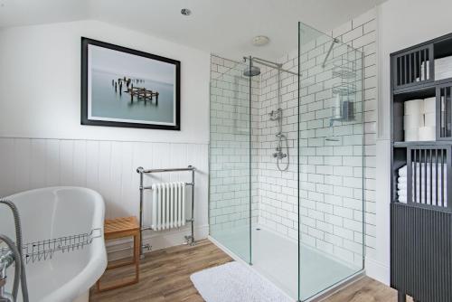 a bathroom with a tub and a glass shower stall at Little Beach House by Bloom Stays in Whitstable
