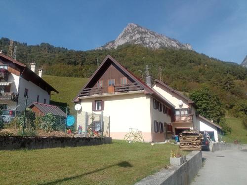 una casa blanca con una montaña en el fondo en Ostello Casa Morit, en Pontebba