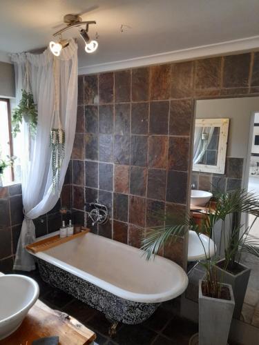 a large bathroom with a tub and two sinks at Fijnbos Guesthouse in Knysna