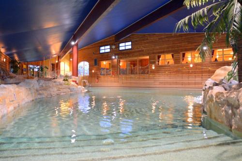 une piscine devant un immeuble dans l'établissement AEC Vacances - Les Becchi, à Samoëns