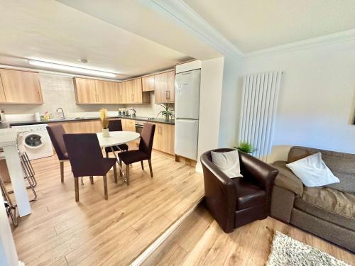 sala de estar con sofá, mesa y cocina en Glen Fern Lodge - Garden Apartment with Parking - Heart of Town Centre - Close to Beach en Bournemouth