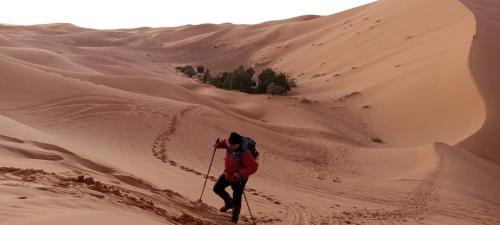 eine Person auf Skiern, die durch die Wüste geht in der Unterkunft BIVOUAC SINAS in Rissani