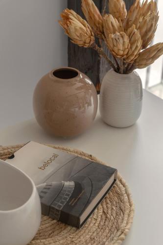 a book sitting on a table next to a vase at HARBOR APARTMENTS - Damrota in Katowice