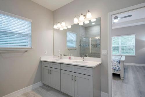 a white bathroom with a sink and a mirror at Amenity-Rich New Build; Dogs OK in Dunnellon