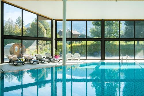una gran piscina con sillas y ventanas en AEC Vacances - Forgeassoud, en Saint-Jean-de-Sixt