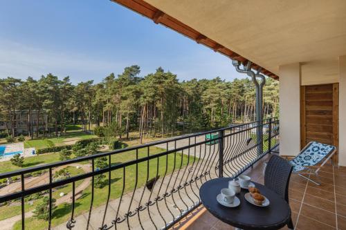 a balcony with a table and chairs and a view of trees at Spacerowa Modern Apartment by Renters in Łukęcin