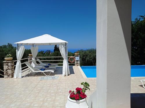 a white gazebo on a patio next to a pool at Villa Katia in Tsoukaladhes