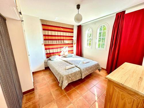 a bedroom with red curtains and a bed in a room at Trinimat Ferienwohnung Teneriffa Nord 2 in Santa Úrsula