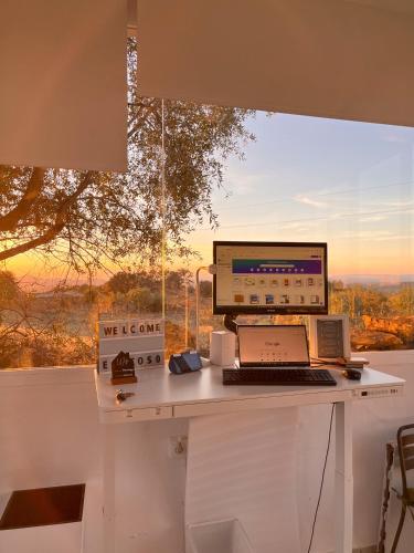 a desk with a computer and a laptop on it at El Coso Lodge & Workation in Zalamea la Real