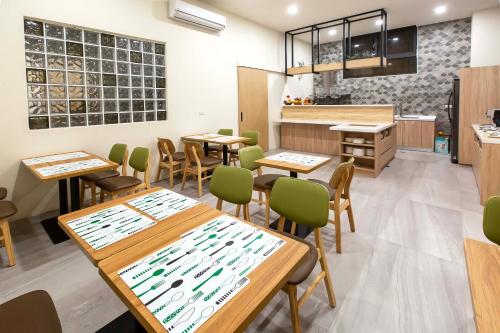 un restaurante con mesas de madera y sillas verdes en 晨煦行旅, en Lugu