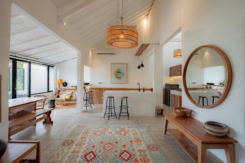 a living room with a mirror and a table at House Sawah - Beautiful & Stylish 3BR Home with Jacuzzi Near Umalas and Seminyak in Kerobokan