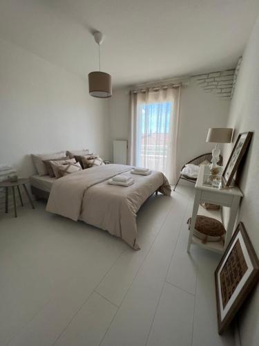 a white bedroom with a bed and a window at Richard's appartement 6 personnes 3 chambres in Pulversheim