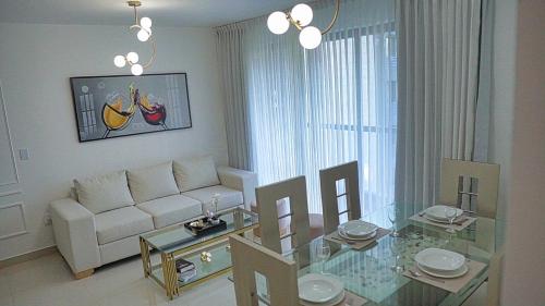 Premium space in Santiago- 5 Min Away from airport في سانتياغو دي لوس كاباليروس: غرفة معيشة مع أريكة بيضاء وطاولة زجاجية