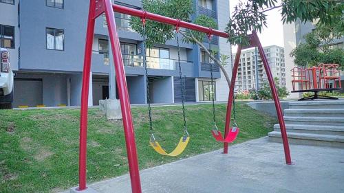 a playground with two swings in a park at Premium space in Santiago- 5 Min Away from airport in Santiago de los Caballeros