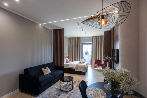 a living room with a blue couch and a bedroom at Kaleo apartments - Hanza Tower in Szczecin