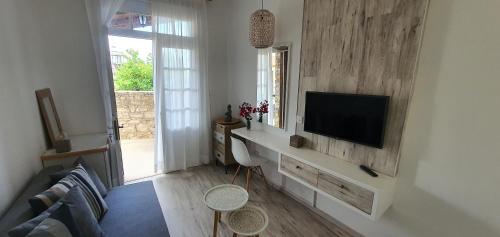 a living room with a television on a wall at Bougainvillea House Lefkara in Pano Lefkara