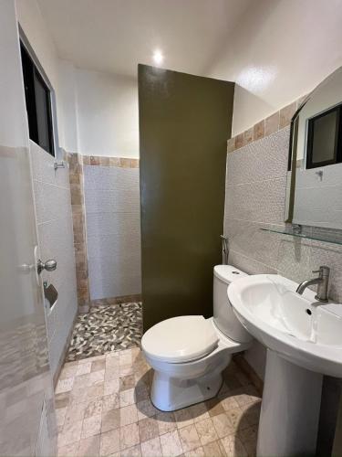 a bathroom with a toilet and a sink at Bulul Garden Resort in El Nido