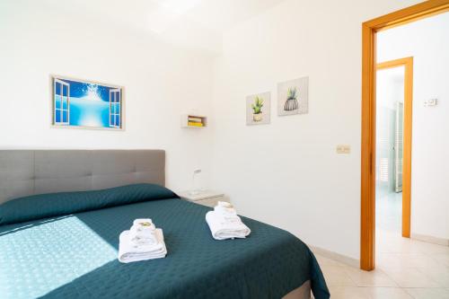 a bedroom with a bed with white shoes on it at Costa Holiday Home in Mascali