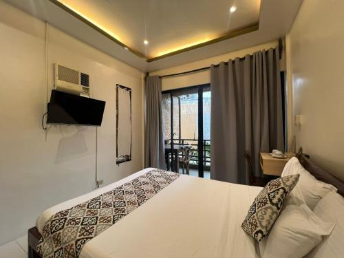 um quarto de hotel com uma cama e uma varanda em Bulul Garden Resort em El Nido