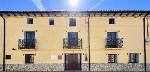 ein gelbes Gebäude mit Fenstern und einer Tür in der Unterkunft Casa Rural La Quinta Del Poeta 