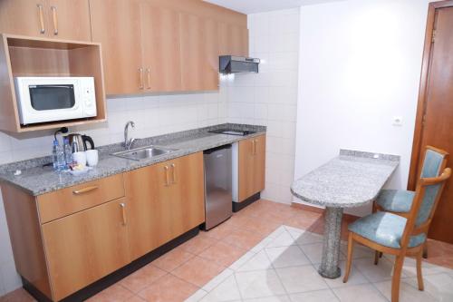 a small kitchen with a sink and a microwave at El Sheikh Suites Hotel in Beirut