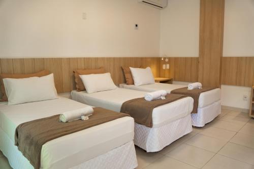 a room with three beds in a room at Pousada Areia do Forte in Cabo Frio