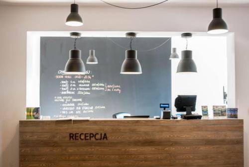 a restaurant with a blue wall with lights above a counter at Przystanek Tleń in Tleń