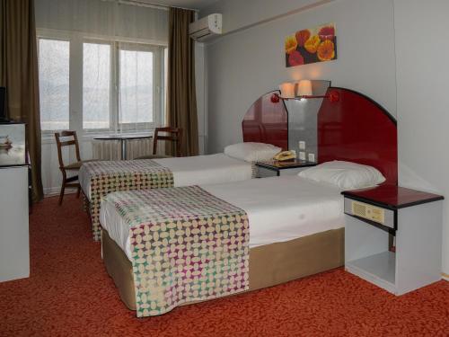 バンドゥルマにあるHOTEL EKENのベッド2台とテーブルが備わるホテルルームです。