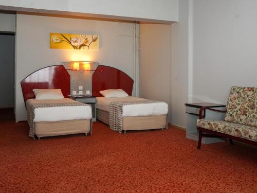 una habitación de hotel con 2 camas y una silla en HOTEL EKEN, en Bandırma