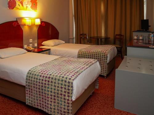 um quarto de hotel com duas camas e uma mesa em HOTEL EKEN em Bandırma