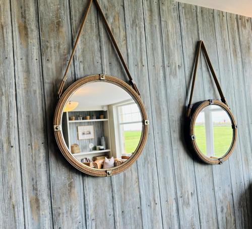 a mirror on a wall with two mirrors on it at Beach House Hotel in Seahouses