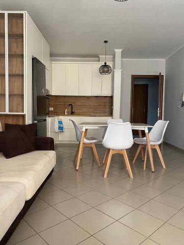 een woonkamer met een bank en een tafel en stoelen bij Globe apartement in Tirana